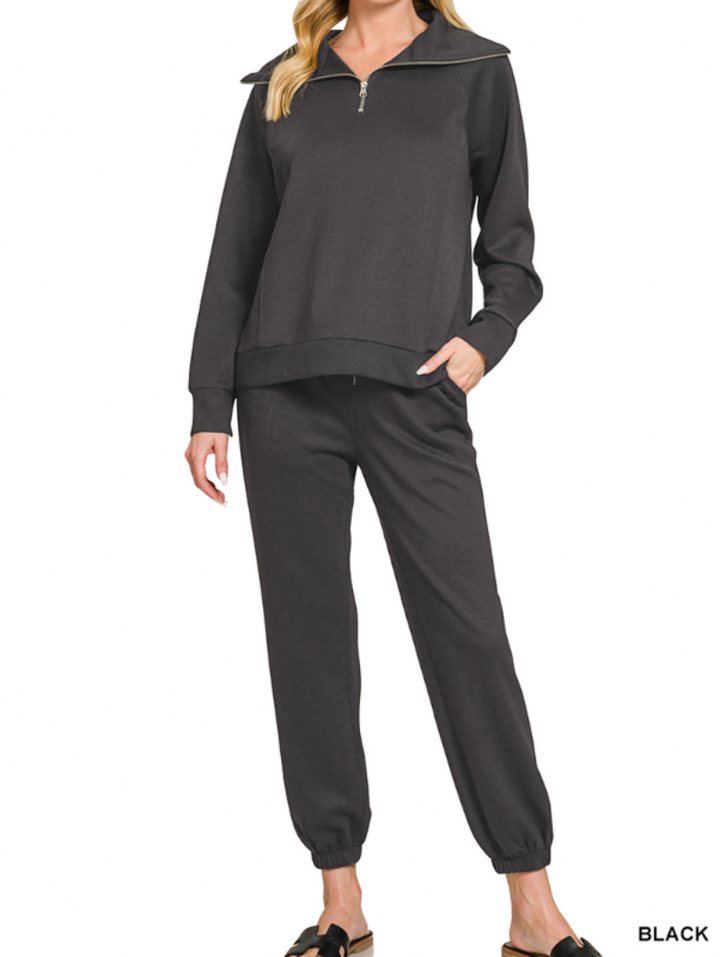 Woman wearing 2-piece set half zip top and pants gathered at the bottom