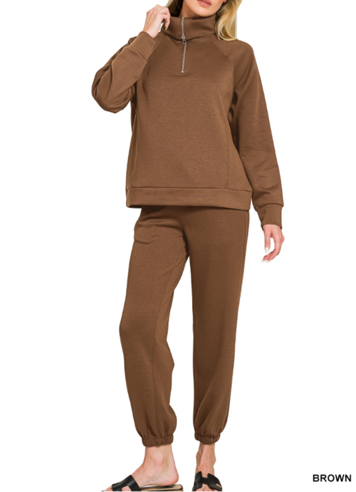 Woman wearing 2-piece set half zip top and pants gathered at the bottom