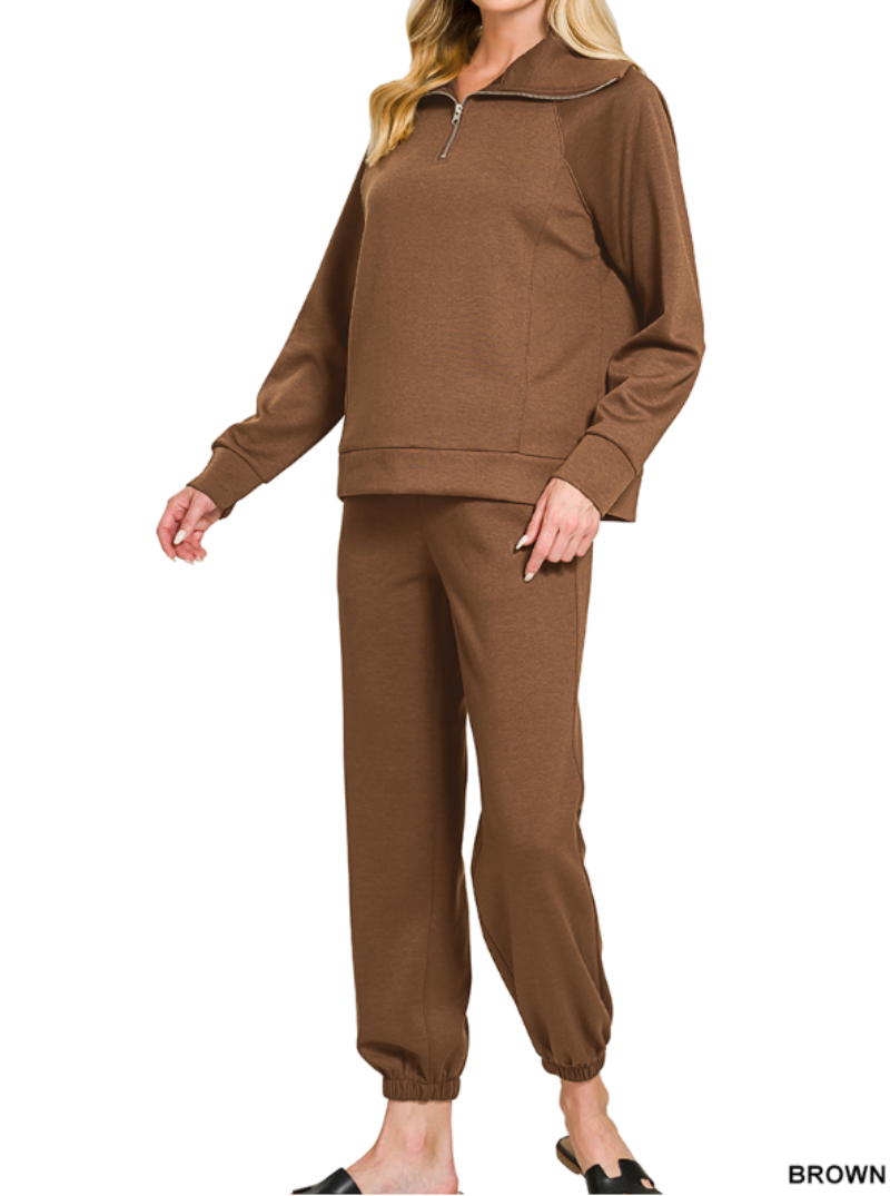 Woman wearing 2-piece set half zip top and pants gathered at the bottom