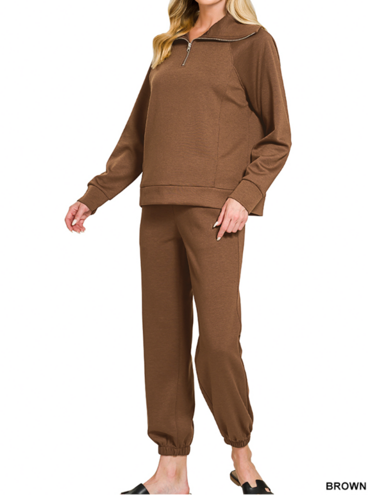 Woman wearing 2-piece set half zip top and pants gathered at the bottom