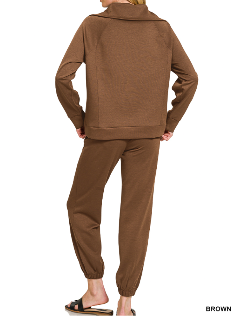 Woman wearing 2-piece set half zip top and pants gathered at the bottom