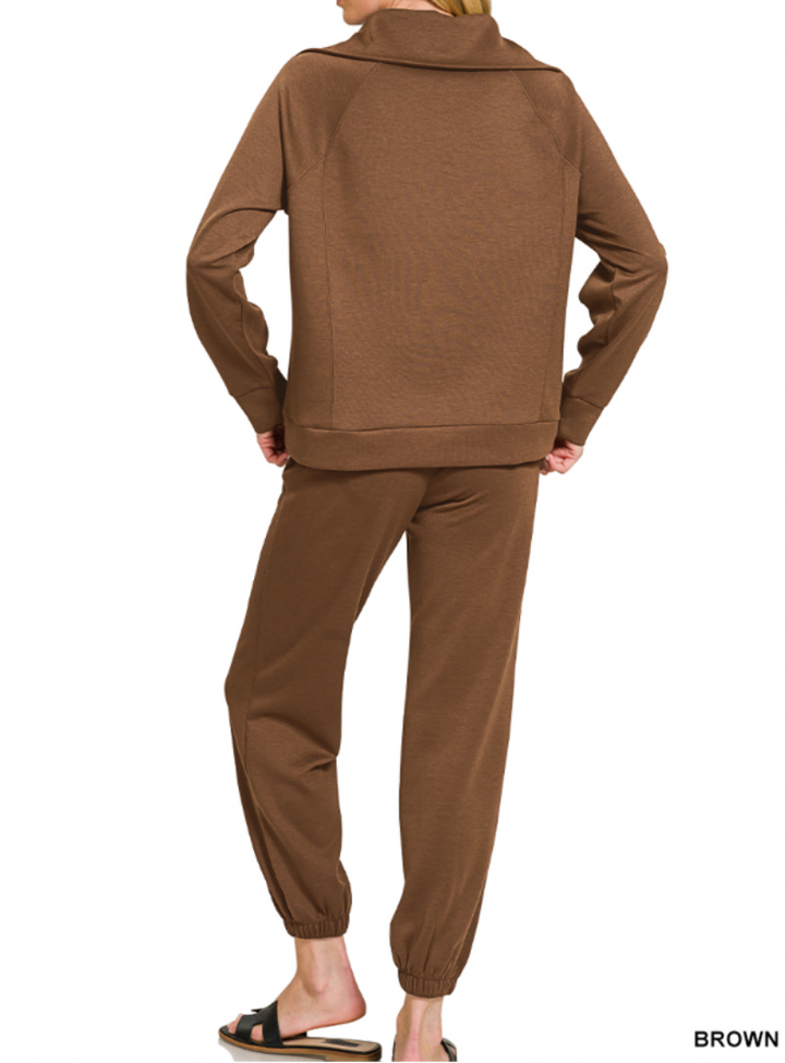 Woman wearing 2-piece set half zip top and pants gathered at the bottom
