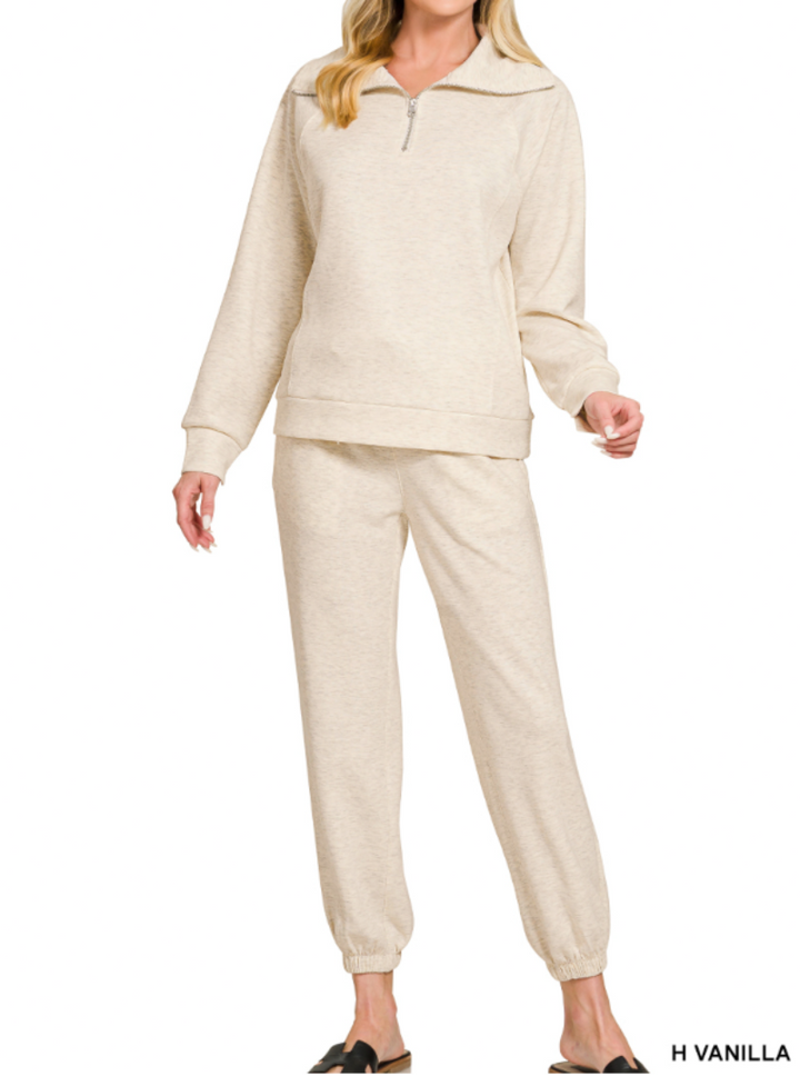 Woman wearing 2-piece set half zip top and pants gathered at the bottom