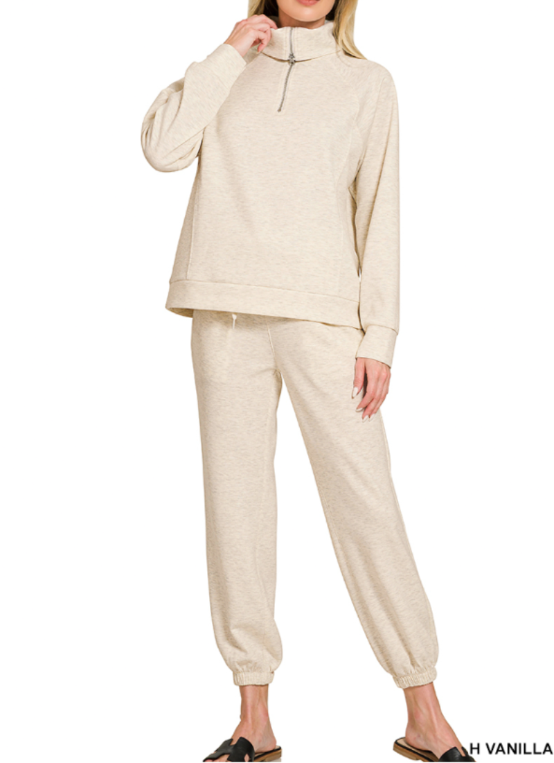 Woman wearing 2-piece set half zip top and pants gathered at the bottom