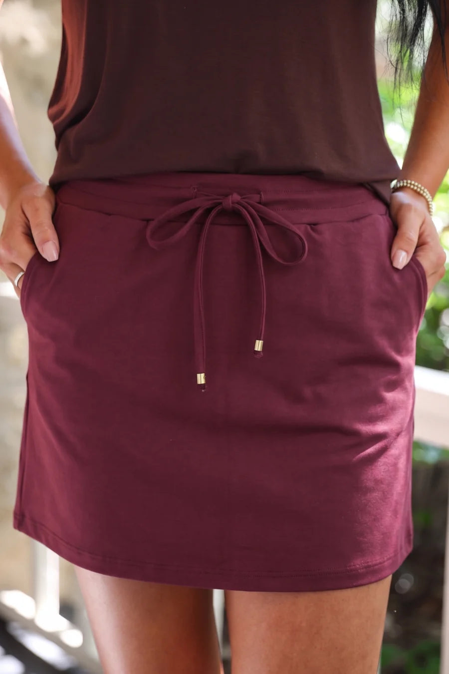 Burgundy skort worn by a person standing.