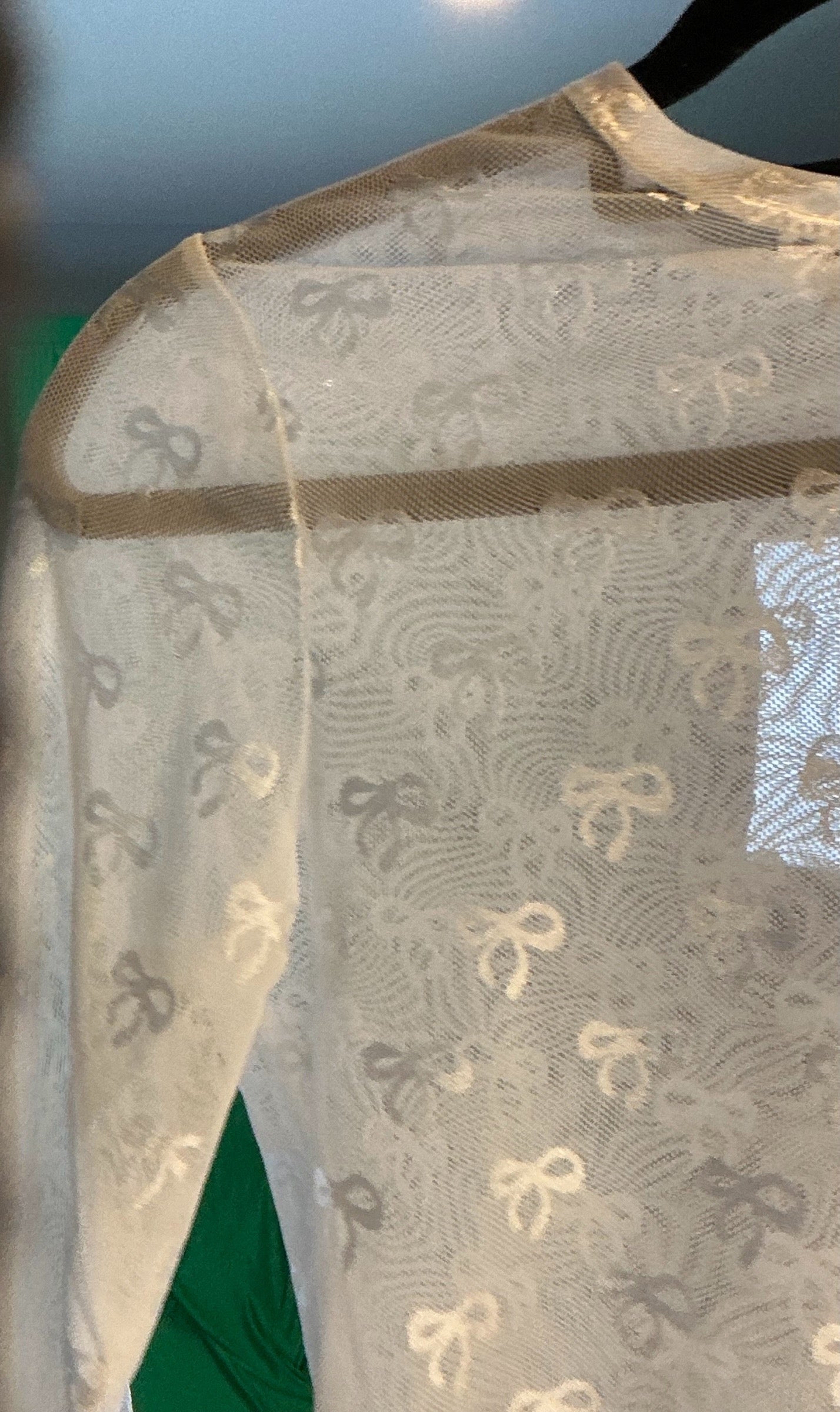 White garment with gold bow pattern on a blurred background