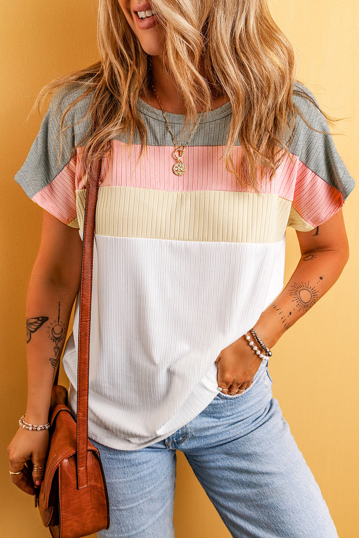 Woman wearing a colorful striped shirt with a yellow background