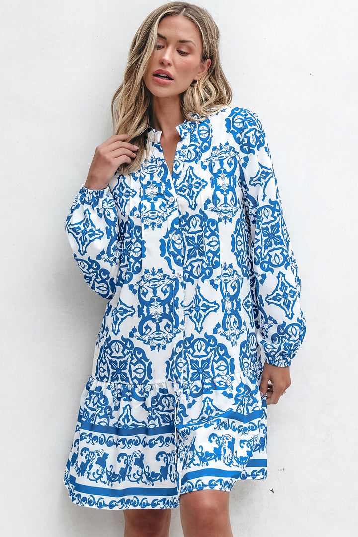 Woman wearing a blue and white patterned dress against a white background
