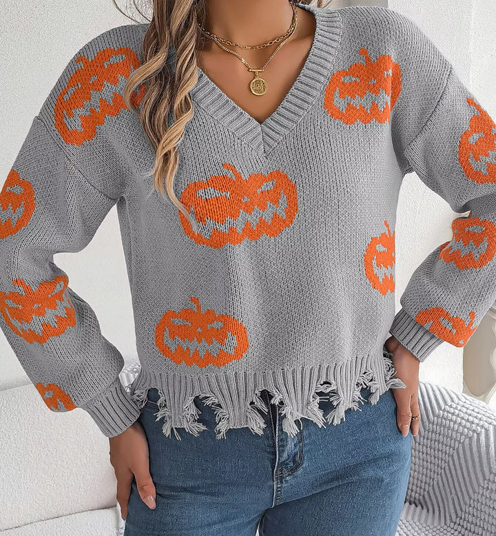 Women wearing grey sweater with pumpkins on it while hands on hips