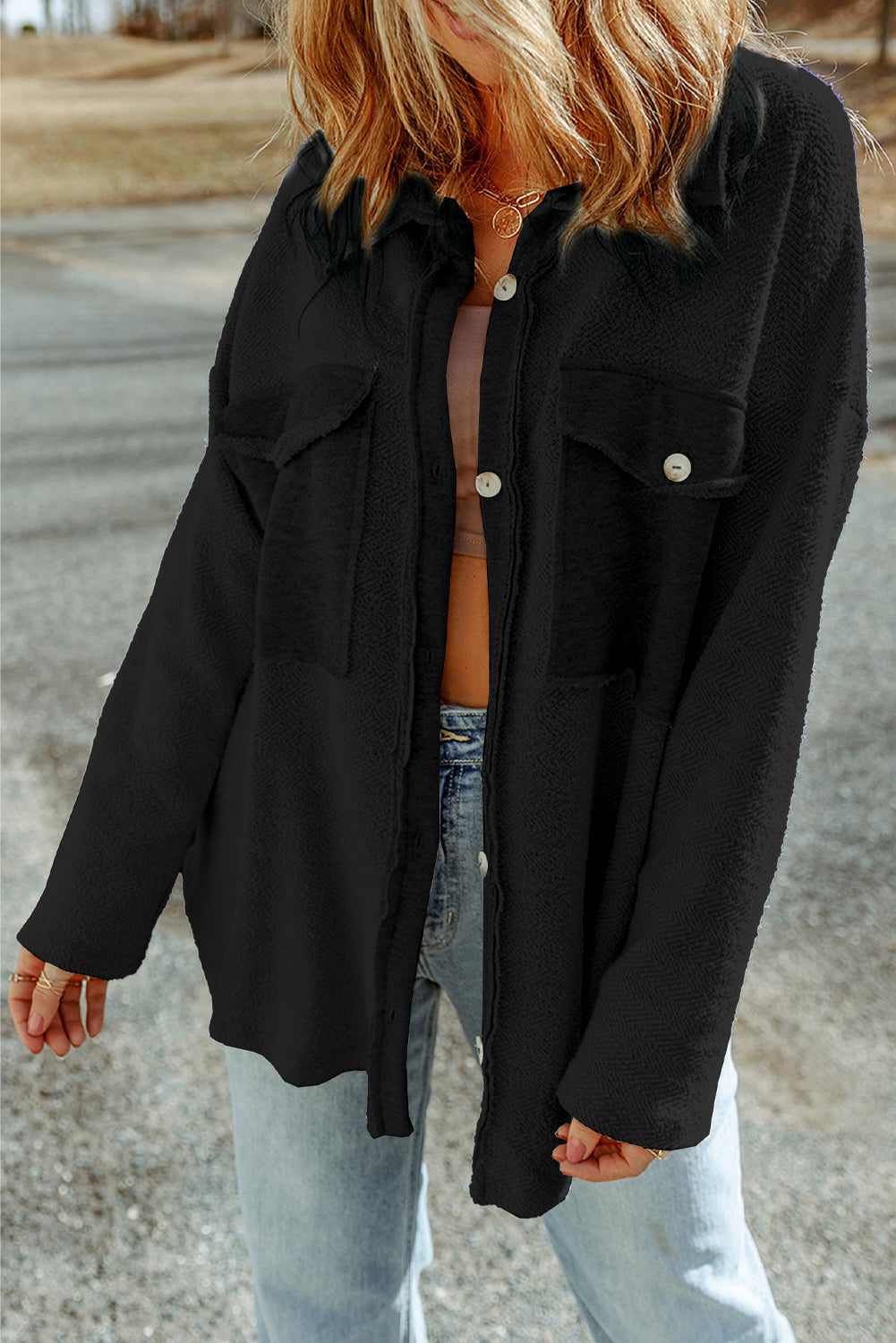 Person wearing a black jacket over a striped shirt with a blurred background
