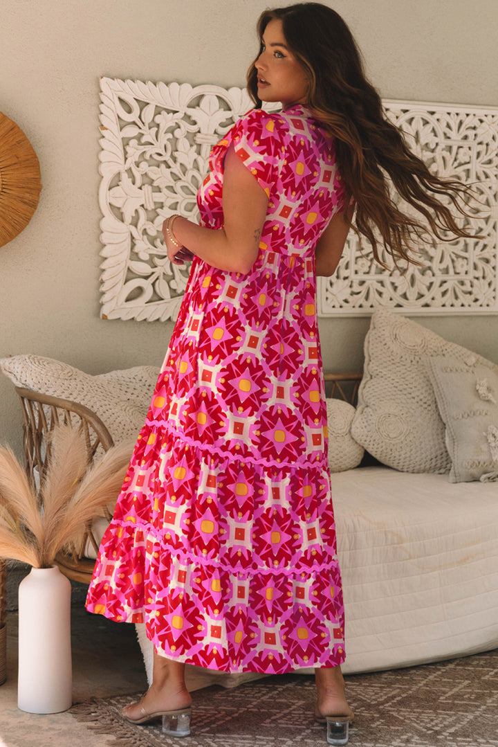 Woman in a pink floral dress standing in a living room.
