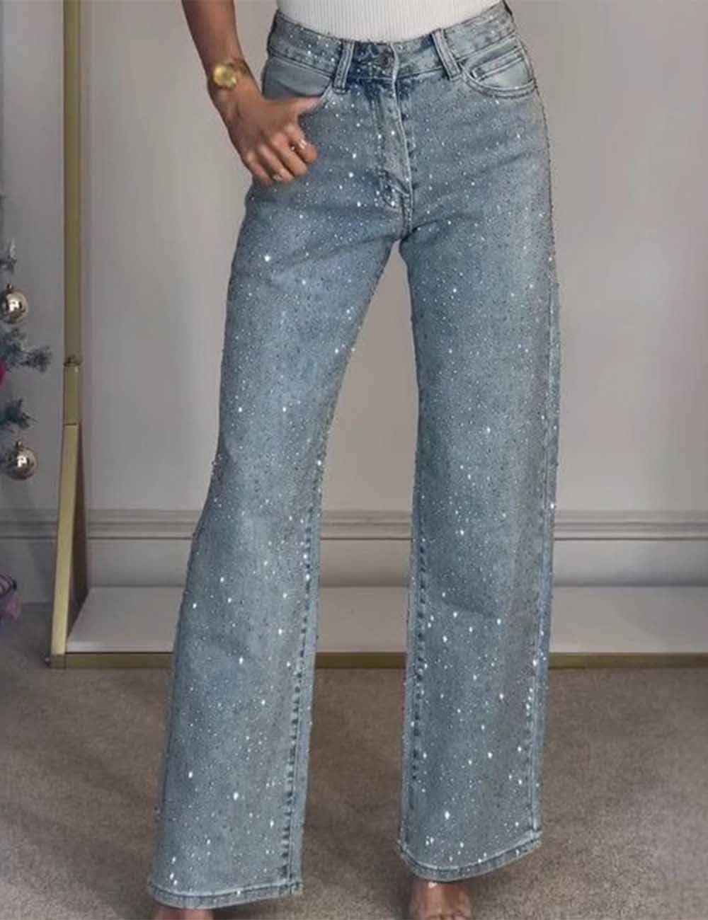 Person wearing sparkly blue jeans indoors with a neutral background