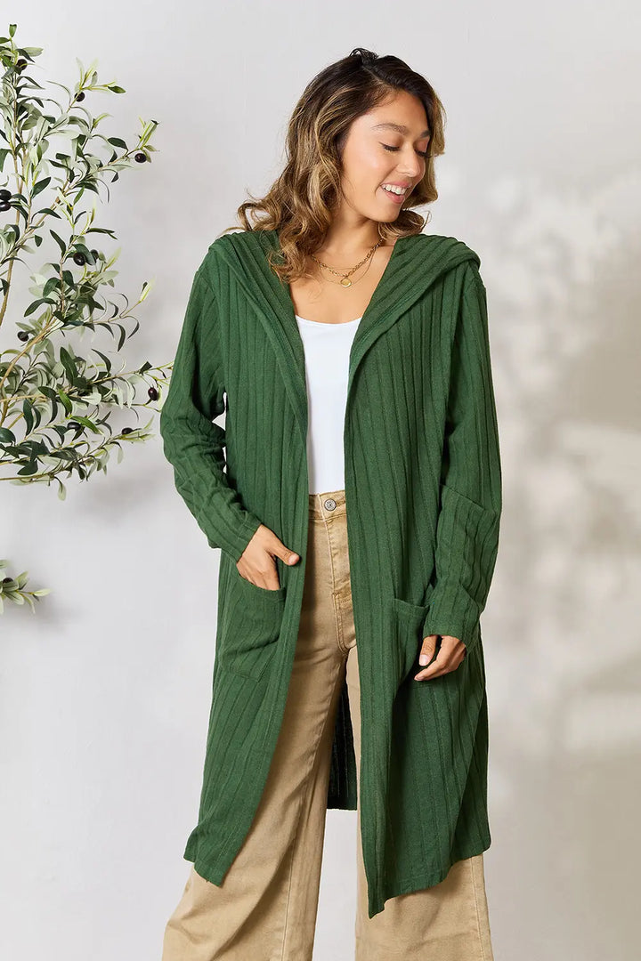 Woman wearing a green cardigan with a white background