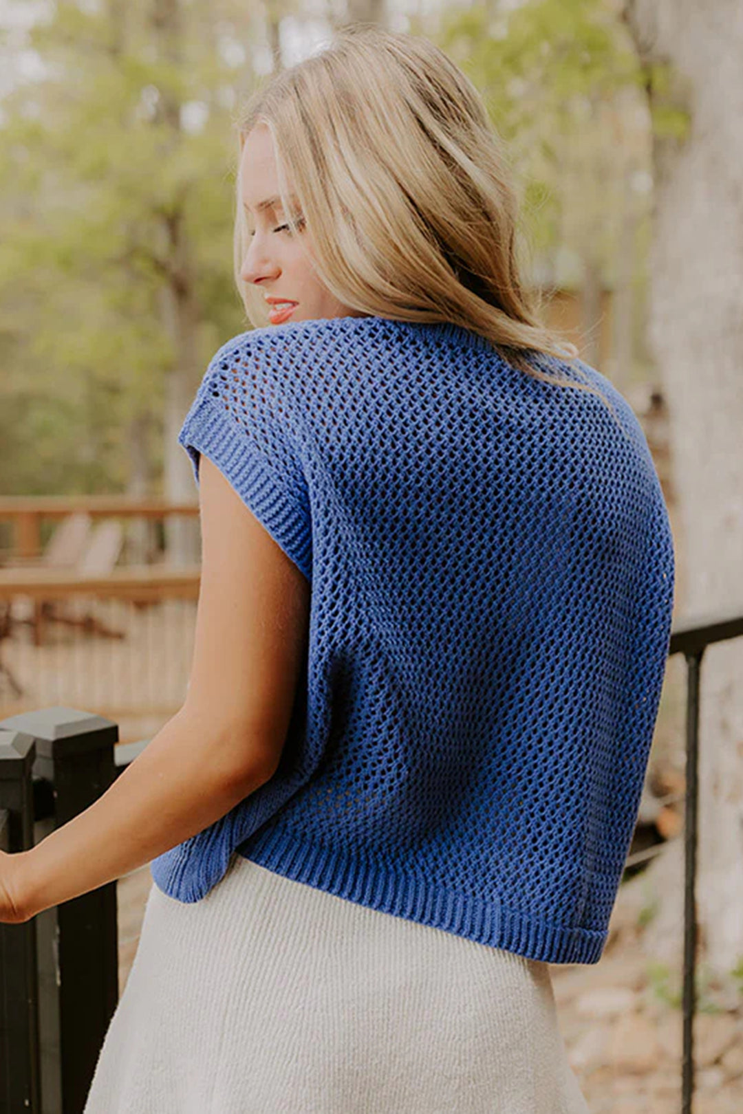 Woman wearing a blue knitted top outdoors