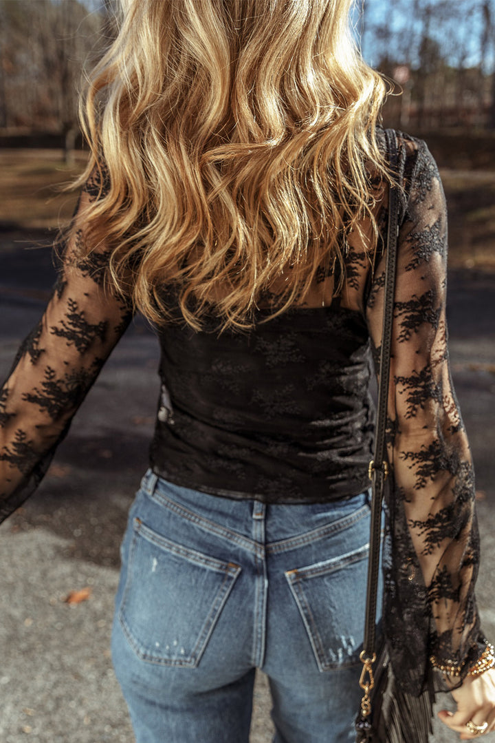 Person wearing a black top and blue jeans with a blurred background