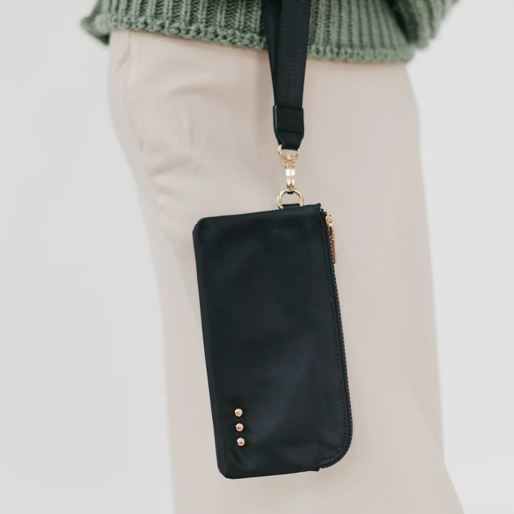 Black wristlet wallet hanging from arm