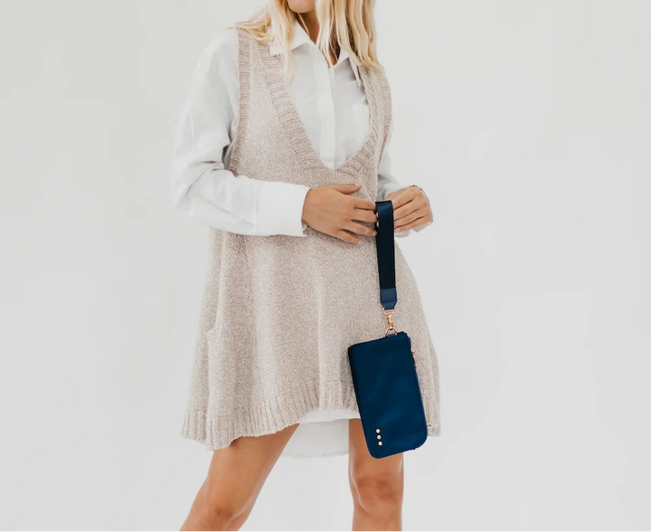 Woman holding a navy wristlet wallet