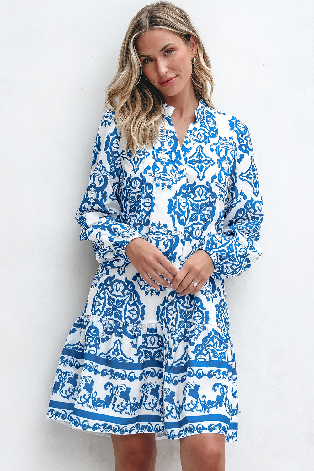 Woman wearing a blue and white patterned dress against a white background