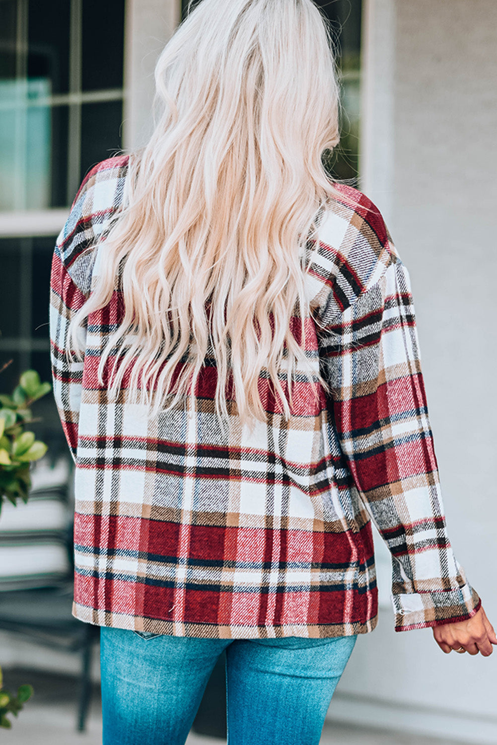 Person wearing a plaid shirt with a blurred background