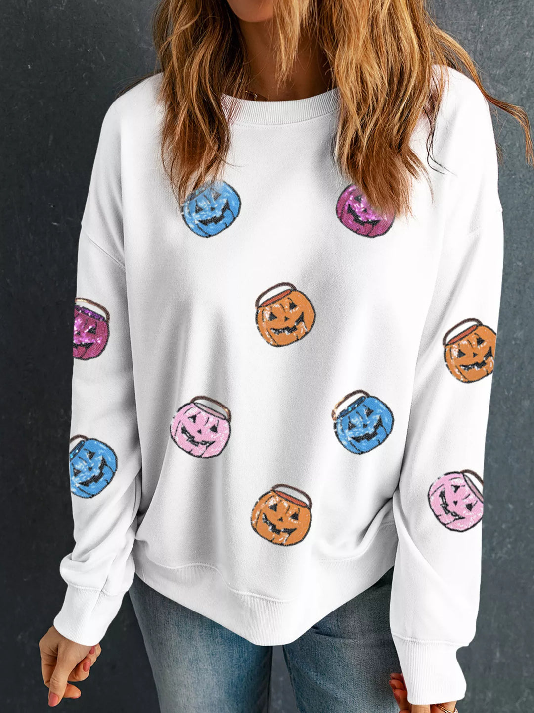 Women wearing a white sweatshirts with blue purple orange and pink small Halloween buckets