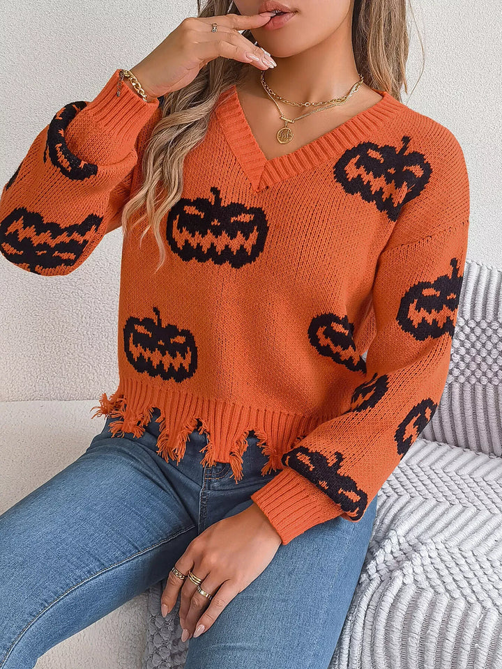 Women wearing orange sweater with black pumpkins on it while sitting