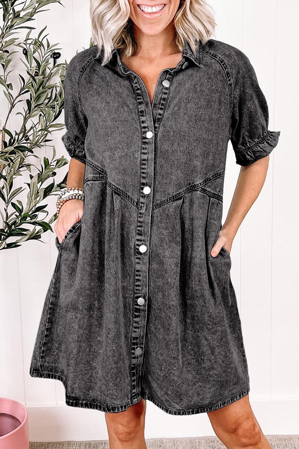 Woman wearing a gray denim dress with a white background