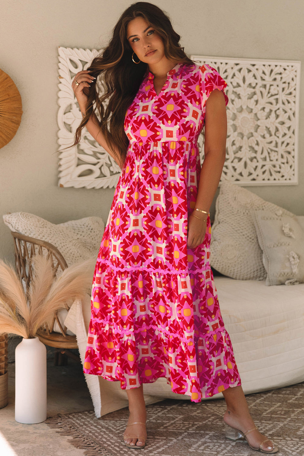 Woman wearing a pink patterned dress in a living room setting