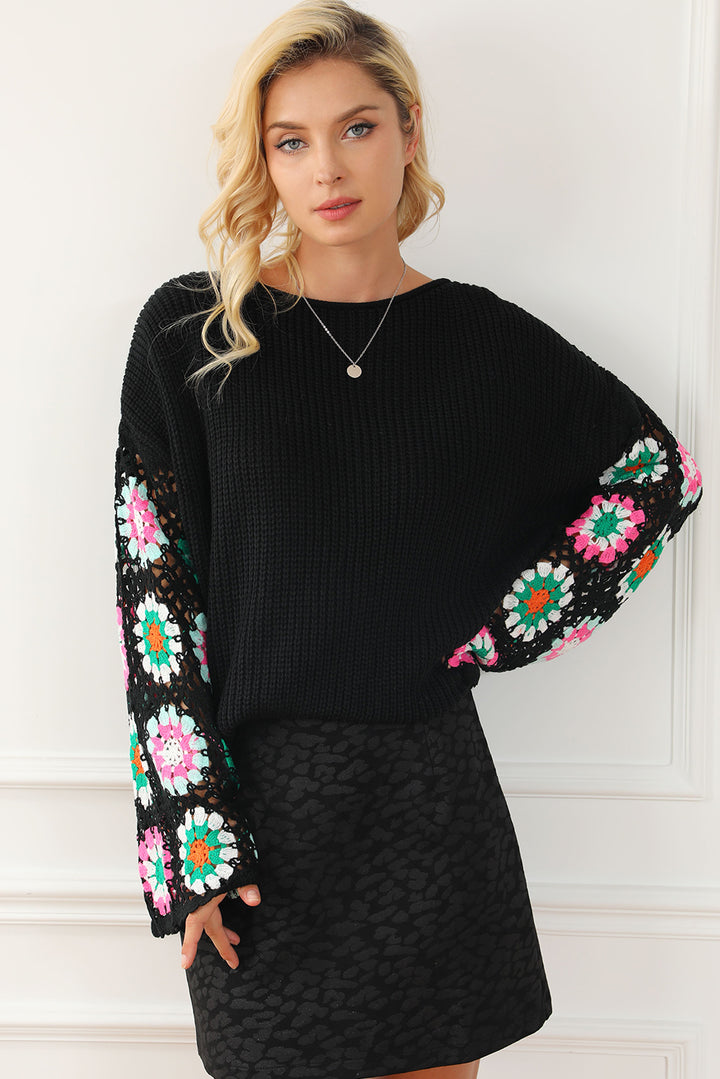 Woman wearing a black dress with colorful floral patterns on the sleeves against a white background
