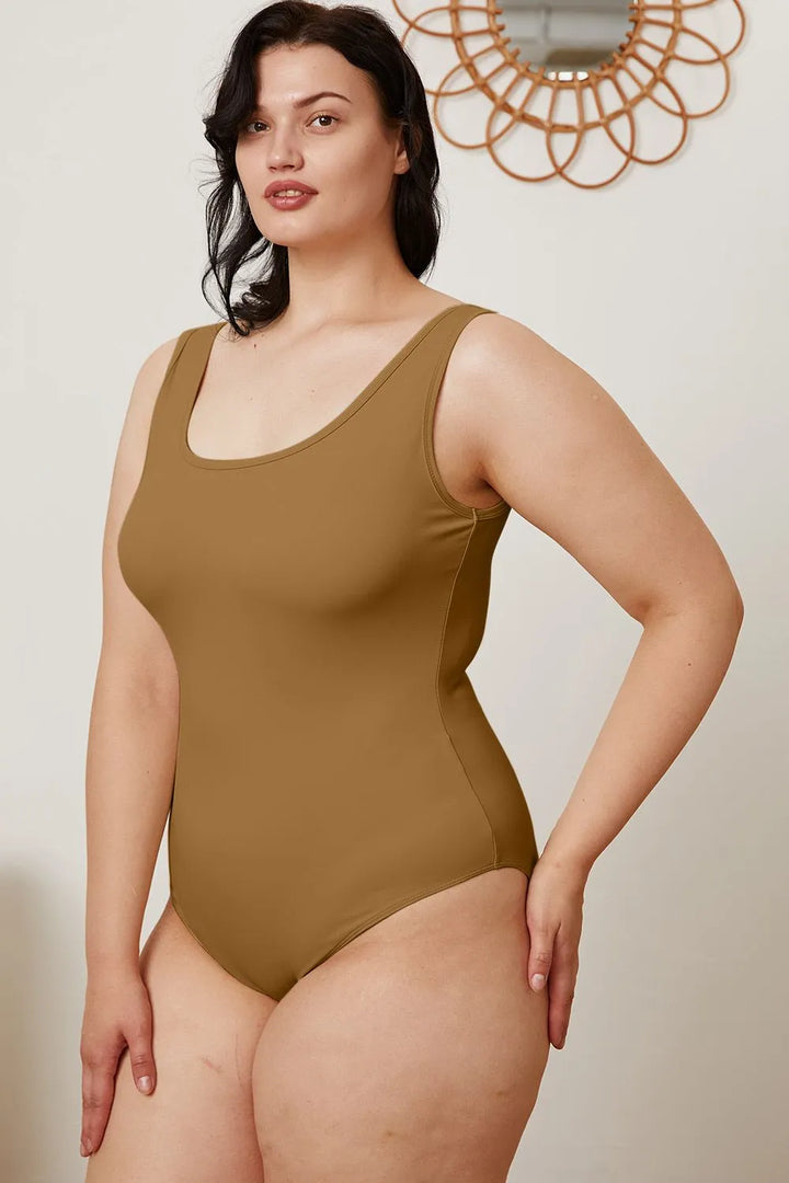 Woman wearing a brown bodysuit against a neutral background