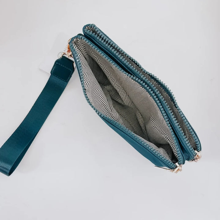 Teal wristlet opened to show inside compartments