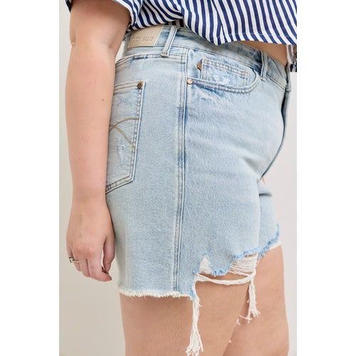 Person wearing a distressed denim skirt with a white background