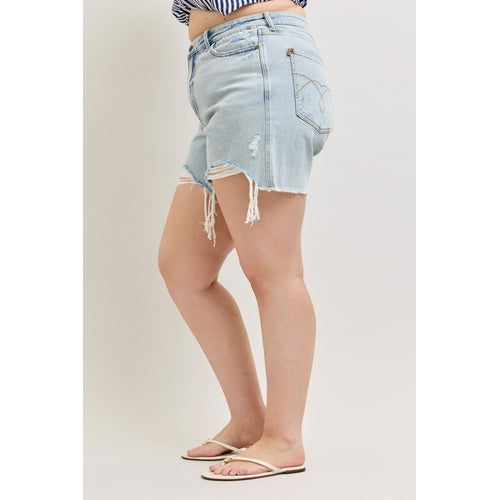 Denim skirt with frayed hem worn by a person on a plain background