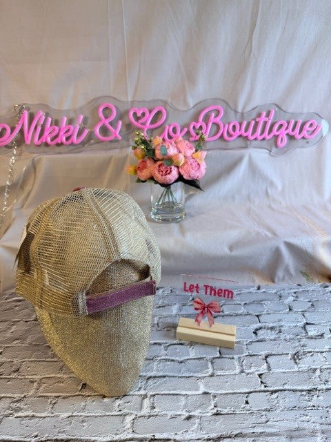 Neon sign reading 'Nikki & Lo's Boutique' with a decorative hat and flowers on a white background.