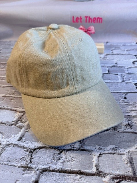 Beige cap with a pink bow on a textured surface