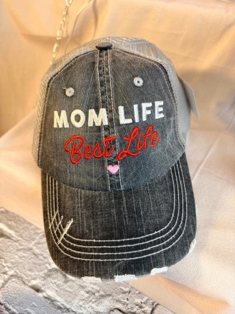 Black distressed cap with 'Mom Life Best Life' text on a wooden surface