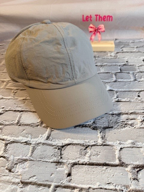 Beige cap on a stand with a brick wall background
