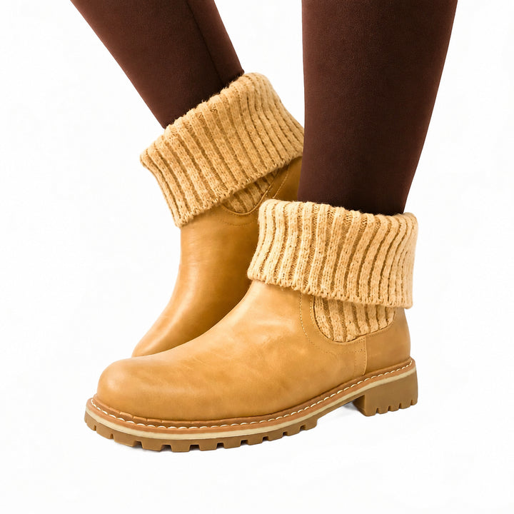 Tan boots with knit leg warmers worn by a person on a white background
