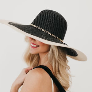 Woman wearing a black and beige sun hat on a white background