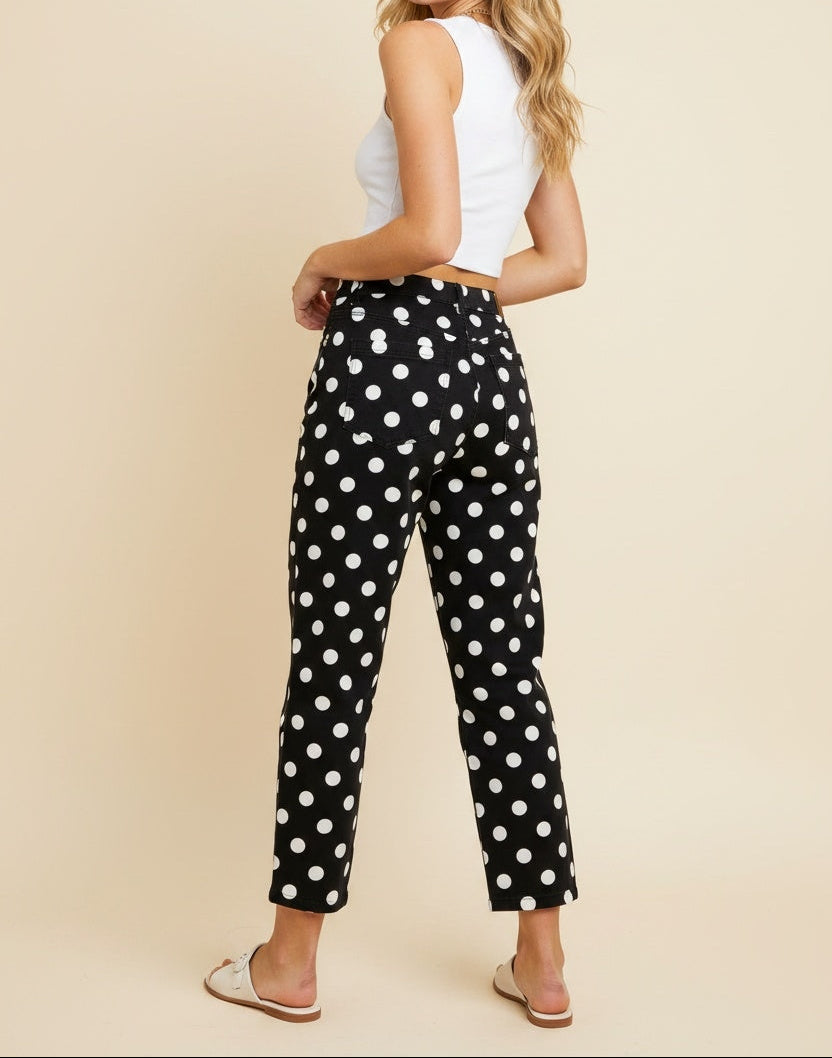 Woman in black pants with white polka dots facing backwards.