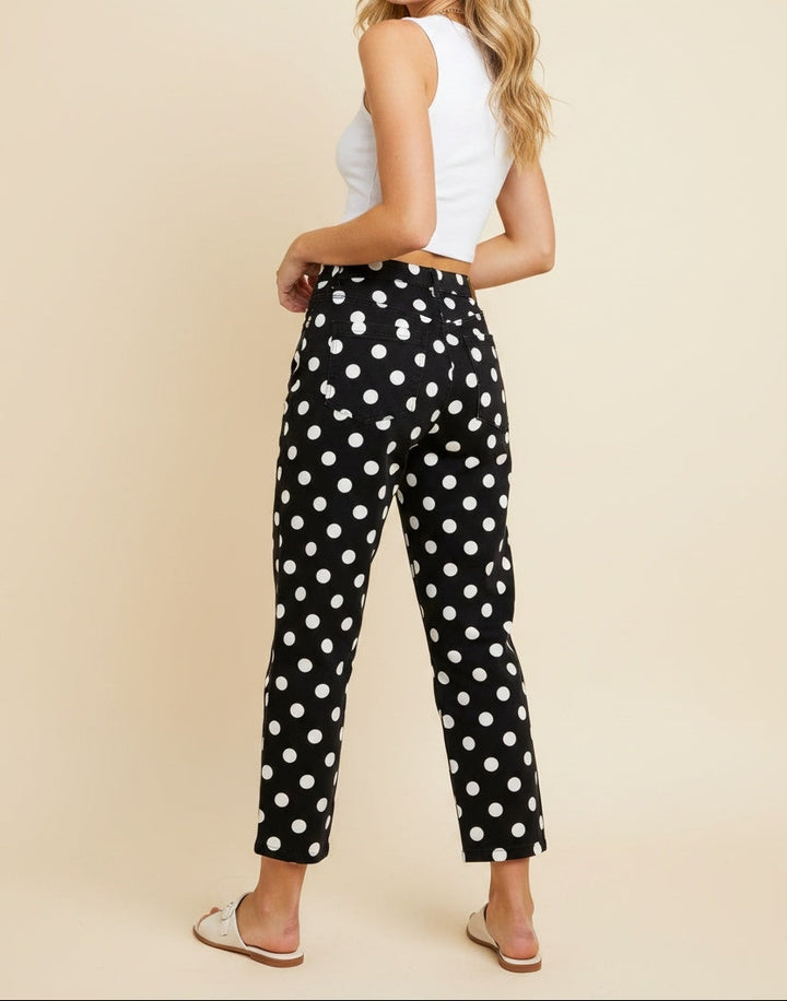 Woman in black pants with white polka dots facing backwards.