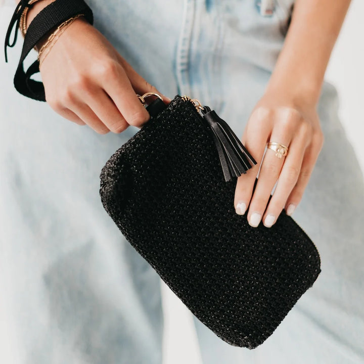 Person holding a black wristlet wallet